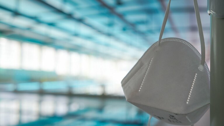 Schwimmhalle mit einer FFP2-Maske