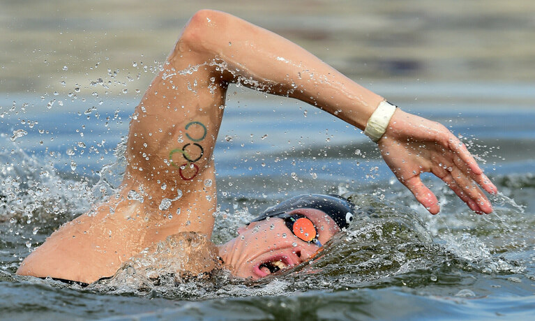Ein mann schwimmt mit brille und haube