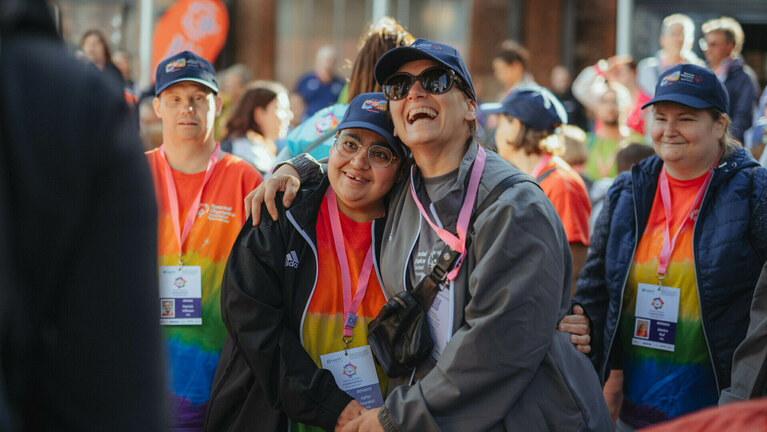 Zwei Athleten von Special Olympics umarmen sich bei der Eröffnungsfeier und lachen