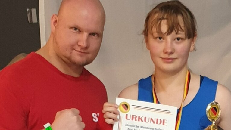 Boxerin und Trainer mit Pokal.