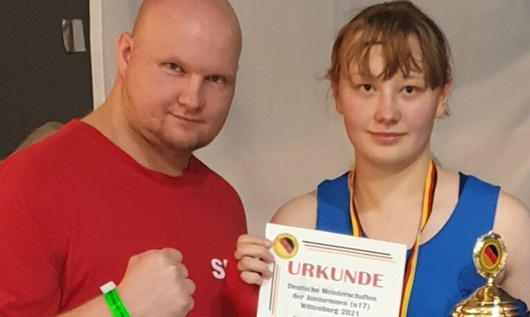 Boxerin und Trainer mit Pokal.