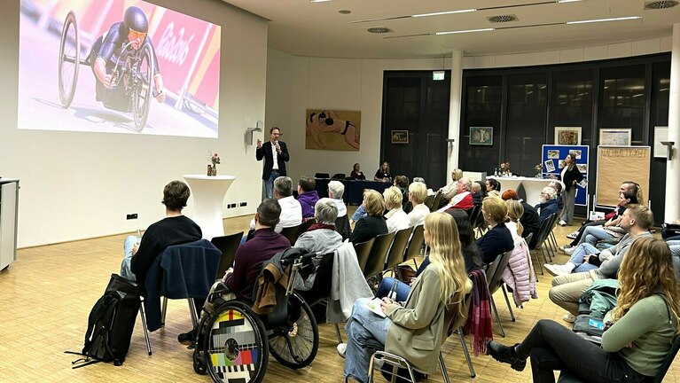 Seminarfoto im Tagungsraum mit Referent und Teilnehmenden