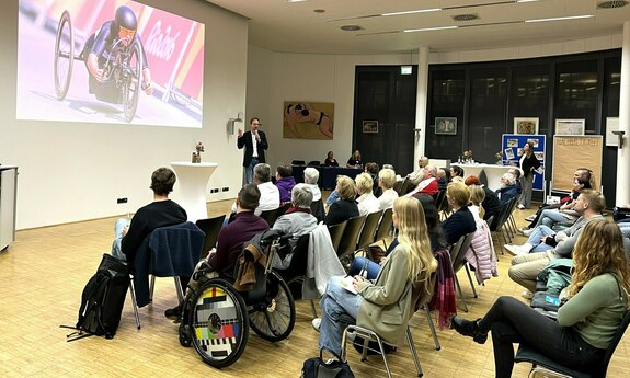 Seminarfoto im Tagungsraum mit Referent und Teilnehmenden