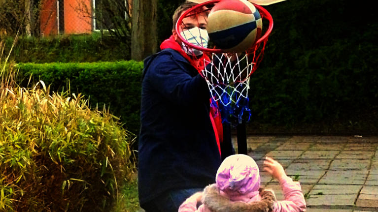 Kinder spielen draußen Basketball.