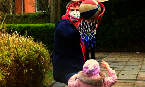Kinder spielen draußen Basketball.