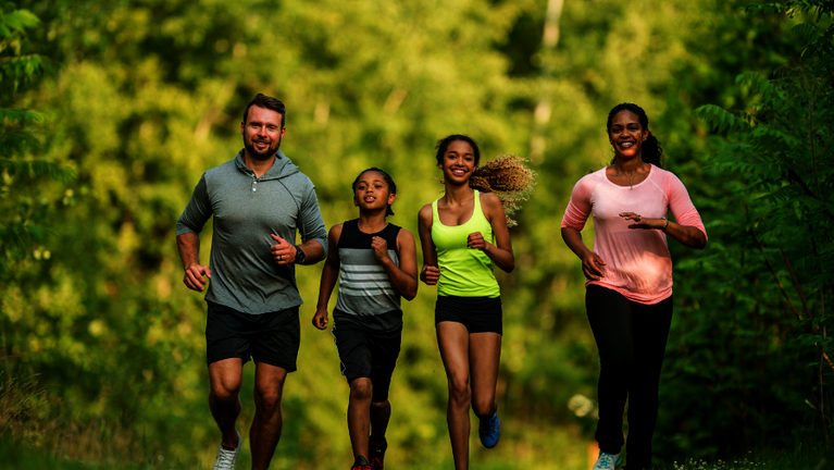 Eine Familie beim Joggen im Wald.