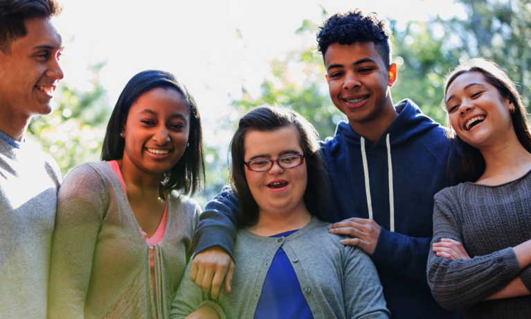 eine Gruppe von Jugendlichen mit und ohne Beeinträchtigung freut sich gemeinsam