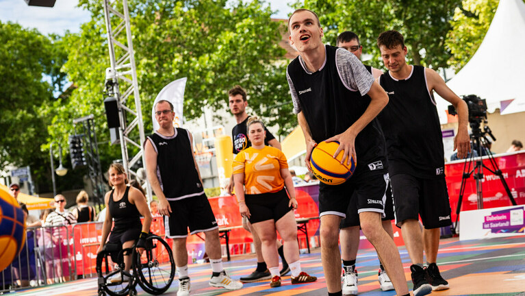 Sportler mit und ohne Behinderung spielen Basketball
