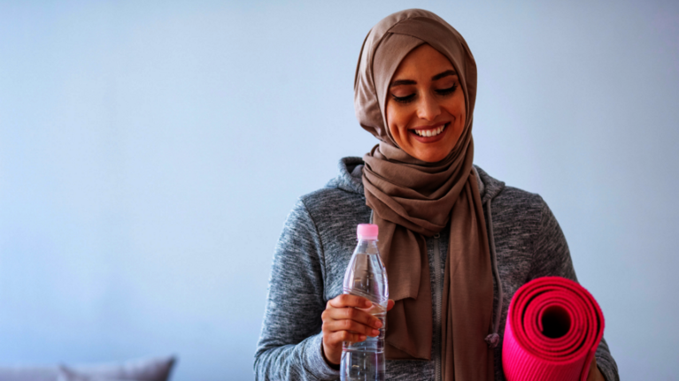 Junge Sportlerin mit Gymnastikmatte.