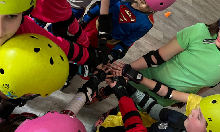 Mehrere Kinder legen ihre Hand aufeinander zur Teamarbeit