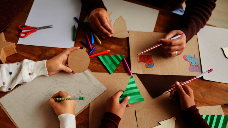 3 Personen basteln für die Weihnachtssaison an einem Tisch