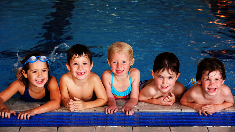 Gruppe von Kindern im Schwimmkurs im Hallenbad