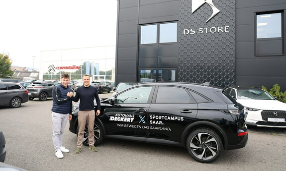 Handschlag bei der Übergabe zwischen dem Geschäftsführer Michael Deckert und des LSVS Mitarbeiter Nick Werner vor dem neuem Geschäftswagen des LSVS