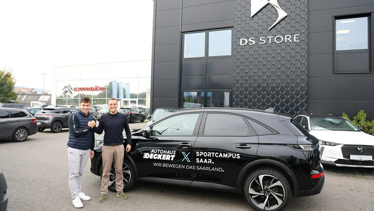 Handschlag bei der Übergabe zwischen dem Geschäftsführer Michael Deckert und des LSVS Mitarbeiter Nick Werner vor dem neuem Geschäftswagen des LSVS