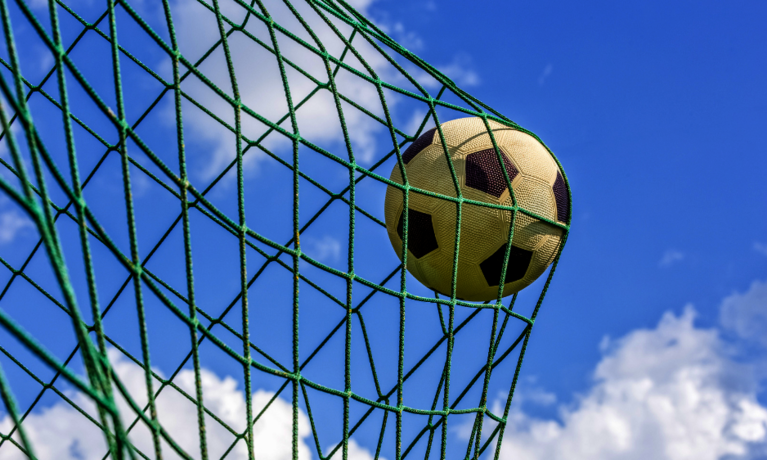 Ein Fußball fliegt in ein Netz