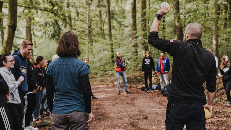 Personen führen eine Diskussion im Wald
