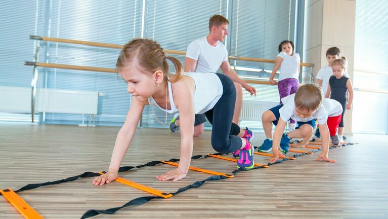 Happy sporty children in gym. Kids exercises Kinder turnen in der Sporthalle
